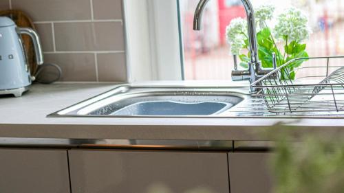 a sink in a kitchen with a window at Modern And Cozy Apex Apartment in Helensburgh