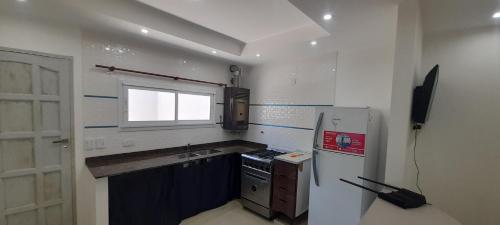 a small kitchen with a stove and a refrigerator at los QUISPER in San Bernardo