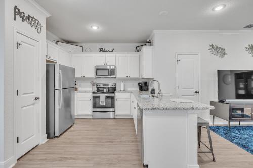 サンアントニオにあるModern 3BR in Gated Community Near JBSA & SeaWorld Duplexの白いキャビネットとカウンタートップを備えたキッチン