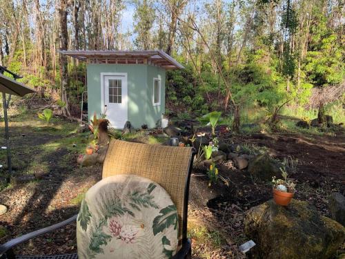 a chair and a small house in the woods at Majestic Banya tree cabin in Mountain View