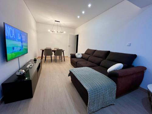 a living room with a brown couch and a table at Cozy Apartment Almada in Almada