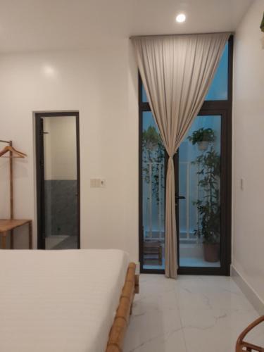 a bedroom with a bed and a large window at Tâm Homestay in Hue