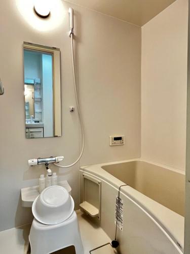 a bathroom with a toilet and a bath tub at Casa Nishikujo by Liaison in Osaka
