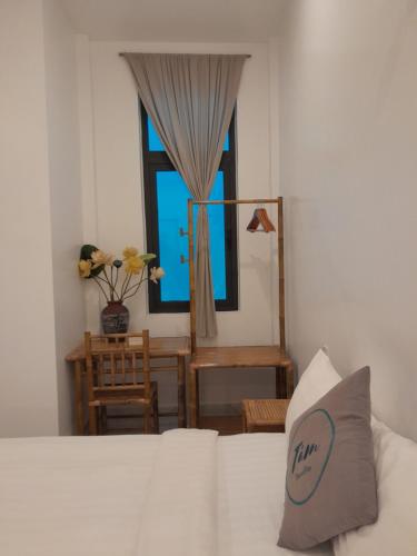 a bedroom with a white bed and a window at Tâm Homestay in Hue