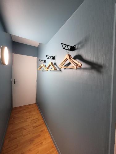 un couloir avec trois cintres de chaussures sur un mur dans l'établissement Charmant studio, à Bagnères-de-Bigorre
