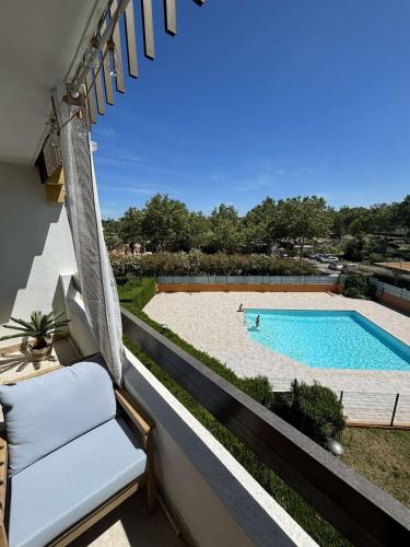 - une vue sur la piscine depuis le balcon d'une maison dans l'établissement Appartement , Le Cap d 'Agde, au Cap d'Agde