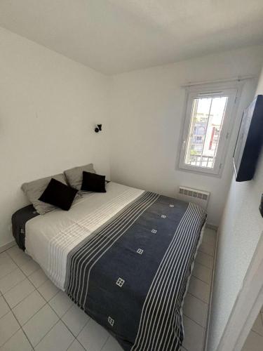 une chambre avec un lit et une fenêtre dans l'établissement Appartement , Le Cap d 'Agde, au Cap d'Agde