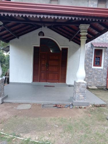a front door of a house with a red door at Rock View Bungalow - Home Stay - Kandy in Kandy