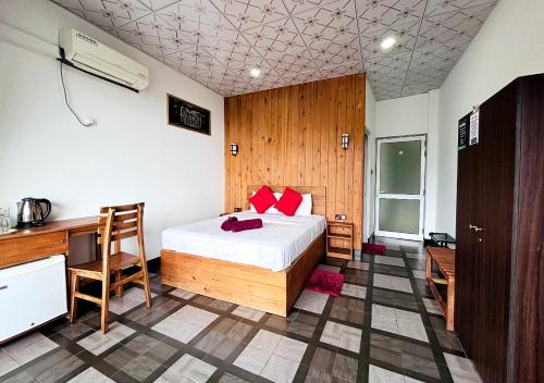 a bedroom with a bed and a desk and a desk at Paraiso Guest House in Ella