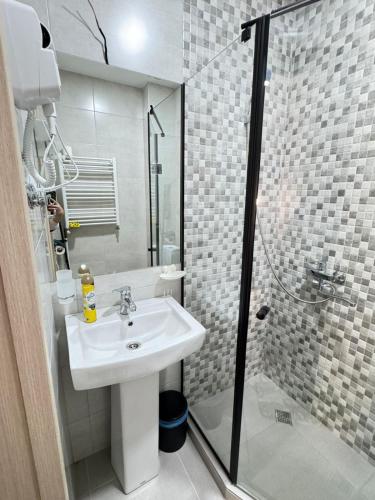 a white bathroom with a sink and a shower at Eco Cottage BaBi in Bakuriani