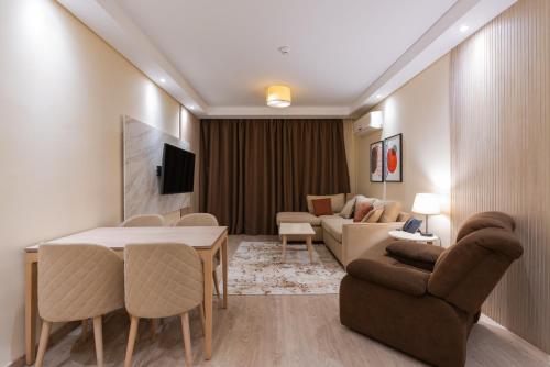 a living room with a couch and a table and chairs at Second Home Hospitality, Rehab City, New Cairo, Cairo Egypt in New cairo