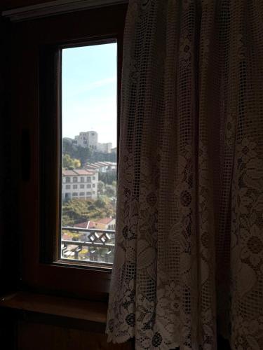 a window with a curtain and a view of a city at --HOTEL DEAL-- Rooms With Castle View in Krujë