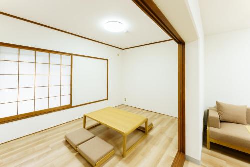 a living room with a table and a chair at 軽井沢七福荘ホテル in Tsumagoi
