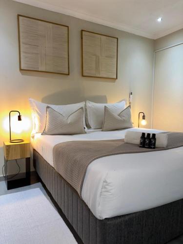 a bedroom with a large bed with white sheets and pillows at SUumthing Private GuestHouse in Lebowakgomo