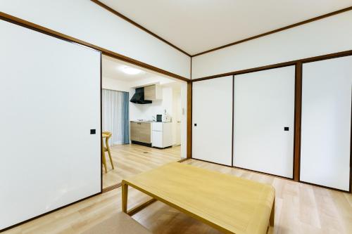 a room with sliding glass doors and a wooden table at 軽井沢七福荘ホテル in Tsumagoi