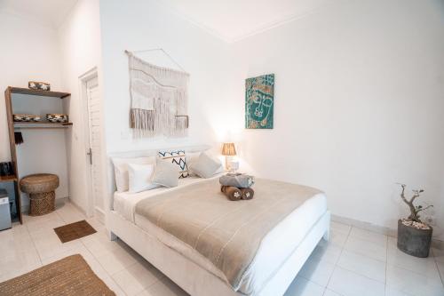 a bedroom with a bed with a teddy bear on it at Sukacita Hill in Uluwatu
