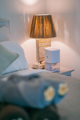 a lamp on a table next to a bed at Sukacita Hill in Uluwatu
