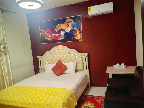 a hotel room with a bed and a painting on the wall at Hongyuan Premier hotel in Accra