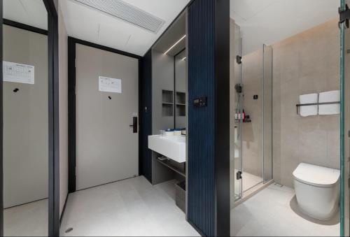 a bathroom with a toilet and a sink at Atour Light Hotel Foshan Shunde Qinghuiyuan Resort in Shunde