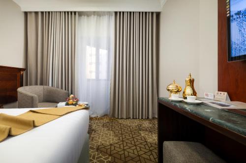 a hotel room with a bed and a television at Emaar Al Manar in Makkah