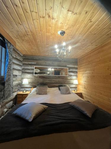 a bedroom with a large bed with a wooden ceiling at Villa Karhunkehto in Luosto