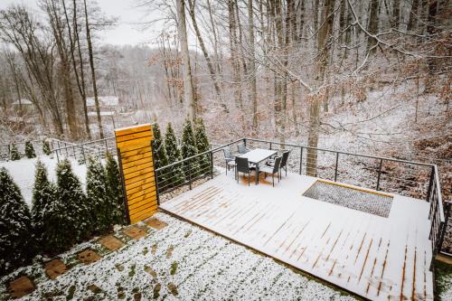 a table and chairs on a deck in the snow at Golden Wood in Sovata