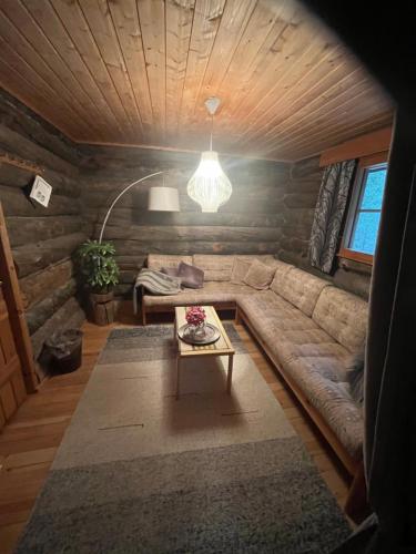 a living room with a couch and a table at Villa Karhunkehto in Luosto