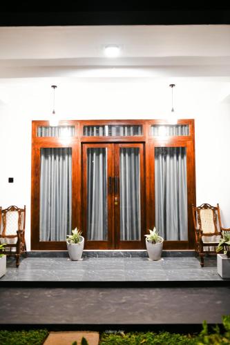 a lobby with wooden doors and chairs and potted plants at The Elite in Udawalawe