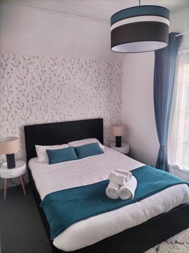 une chambre avec un grand lit avec deux serviettes dessus dans l'établissement Maison à 50 M de la plage sous les pins, à Saint-Brévin-les-Pins