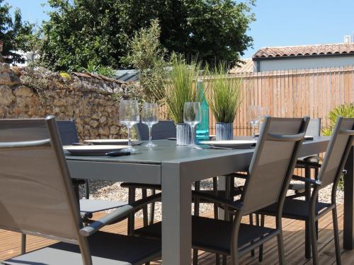 une table et des chaises assises sur une terrasse dans l'établissement Jolie maison 3 étoiles entièrement rénovée, à Fouras