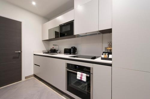 a kitchen with white cabinets and a stove top oven at City Escape - Stylish Studio in Central Reading - CHRL F16 in Reading