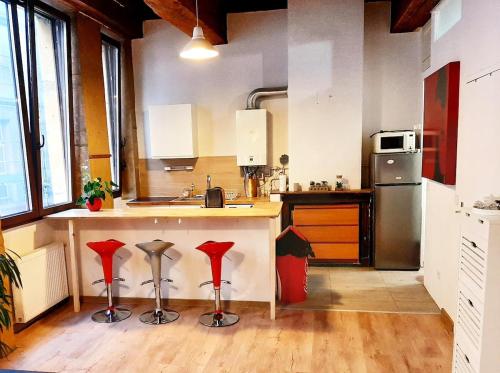 - une cuisine avec un comptoir avec des archets rouges dans l'établissement Lyon Centre Warm apartment full of charm, à Lyon