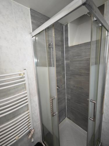 une douche avec une porte vitrée dans une salle de bain dans l'établissement Séjour à Gare de l'Est, à Paris