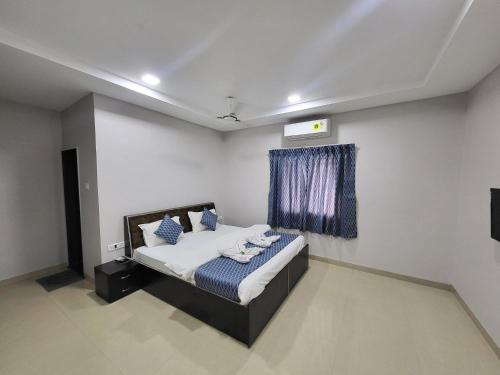 a bedroom with a bed with blue pillows on it at Vayu Resort - Kas Pathar in Kanera