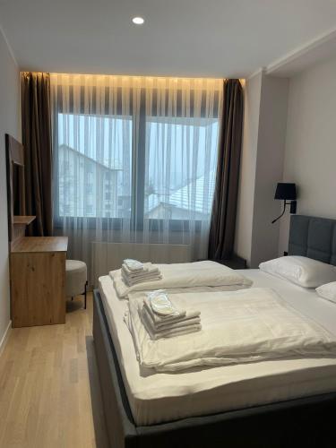a bedroom with two beds and a large window at Moaline Apartments, free parking in Sarajevo