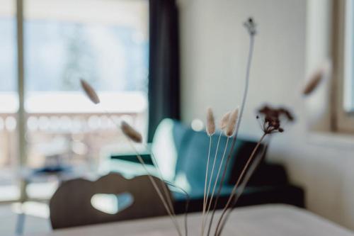 a vase with flowers on a table in a room at Mariengut - Natur Aparthotel Kramer in Wagrain