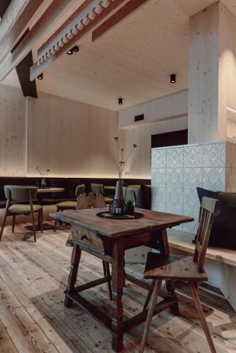 a dining room with a wooden table and chairs at Mariengut - Natur Aparthotel Kramer in Wagrain
