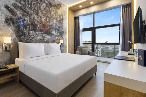 a hotel room with a bed and a large window at Days Inn & Suites by Wyndham Esenyurt in Istanbul
