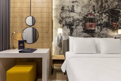 a bedroom with a white bed and a desk and a wall at Days Inn & Suites by Wyndham Esenyurt in Istanbul