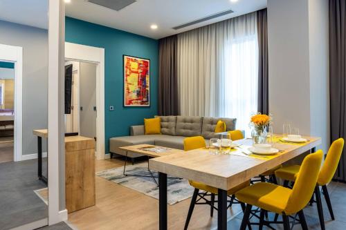 a dining room and living room with a table and yellow chairs at Days Inn & Suites by Wyndham Esenyurt in Istanbul