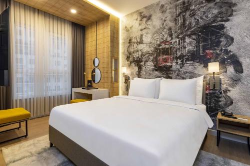 a bedroom with a large white bed and a wall mural at Days Inn & Suites by Wyndham Esenyurt in Istanbul