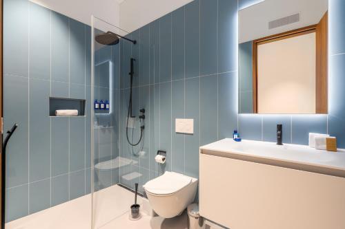 a bathroom with a toilet and a sink and a shower at Swiss Hotel Apartments - Engelberg in Engelberg