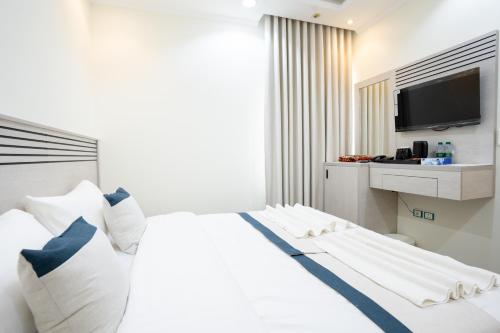 a bedroom with a bed with a tv on the wall at فندق سما ذاخر من اورفانا in Makkah