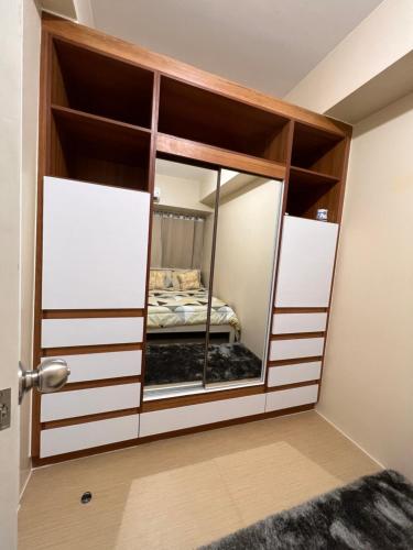 a bedroom with a mirror in a room at Avida Towers Atria in Iloilo City