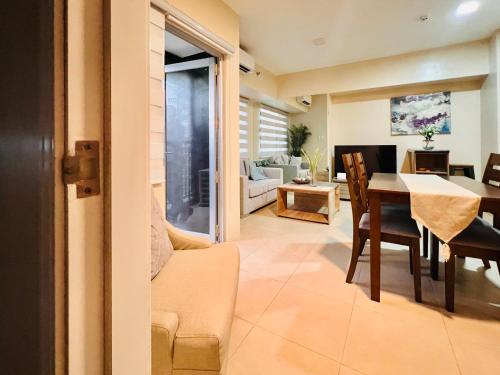 a dining room and living room with a table and chairs at Avida Towers Atria in Iloilo City