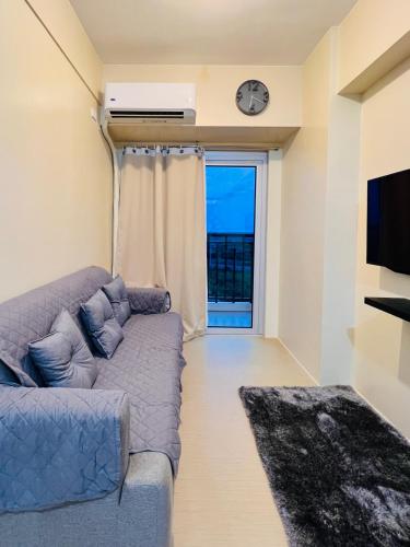a living room with a couch and a window at Avida Towers Atria in Iloilo City