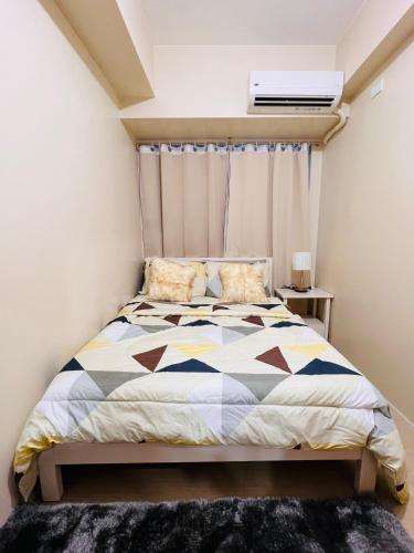 a bedroom with a bed and a window at Avida Towers Atria in Iloilo City
