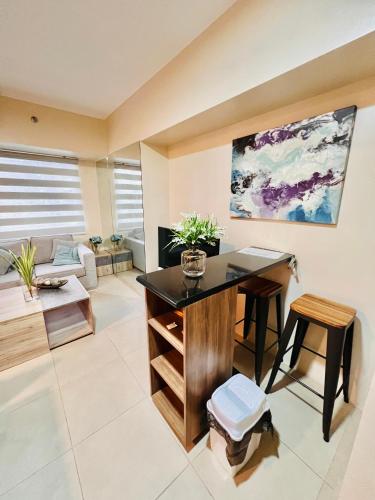 a living room with a desk and a couch at Avida Towers Atria in Iloilo City
