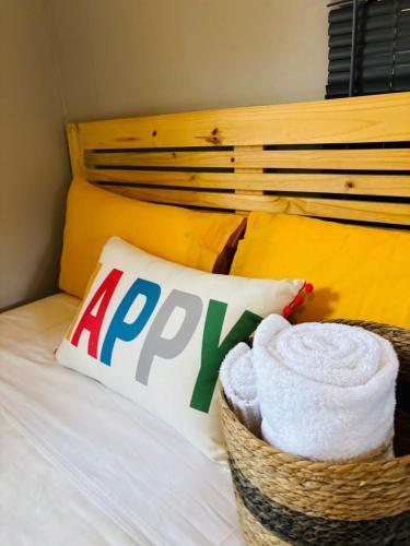 a basket of towels and a pillow on a bed at The Hideaway Cabin in Pretoria