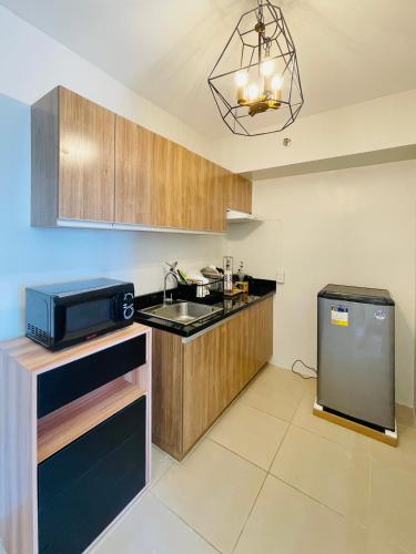 a kitchen with a sink and a microwave at Avida Towers Atria in Iloilo City